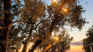 Una zona d'esmorzar a l'aire lliure amb taules, cadires i vistes al capvespre.