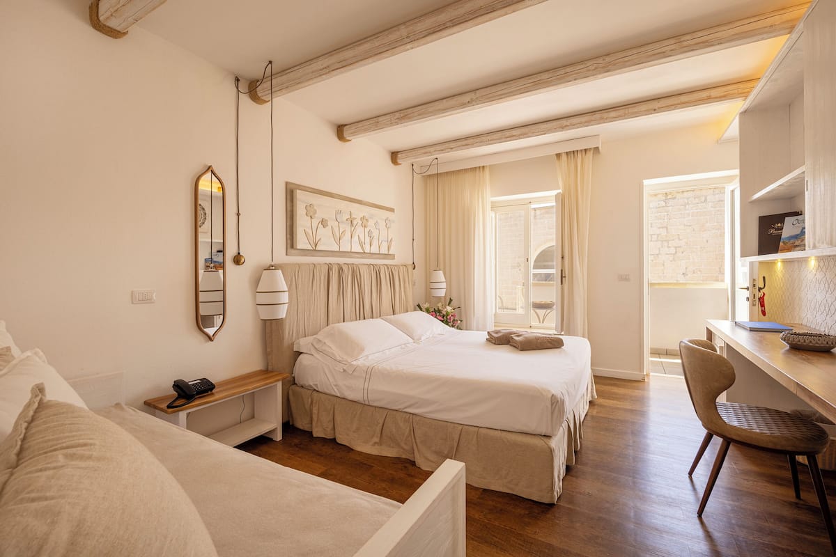 Une chambre à coucher comprenant un lit, une table de chevet, une lampe et un bureau avec une chaise.