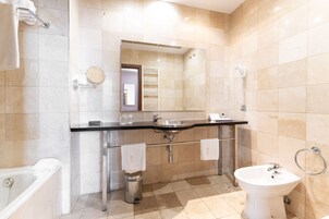 Un baño moderno con lavamanos doble, un bidé, un espejo y un perchero para toallas.