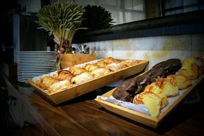 Ein reichhaltiges Buffet mit verschiedenen Backwaren und einer Zierpflanze.