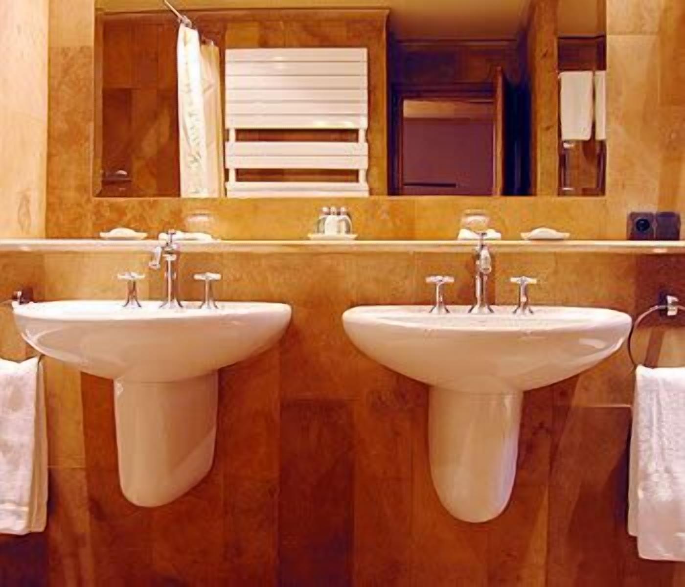 Une salle de bain avec deux lavabos, un miroir et un porte-serviettes.