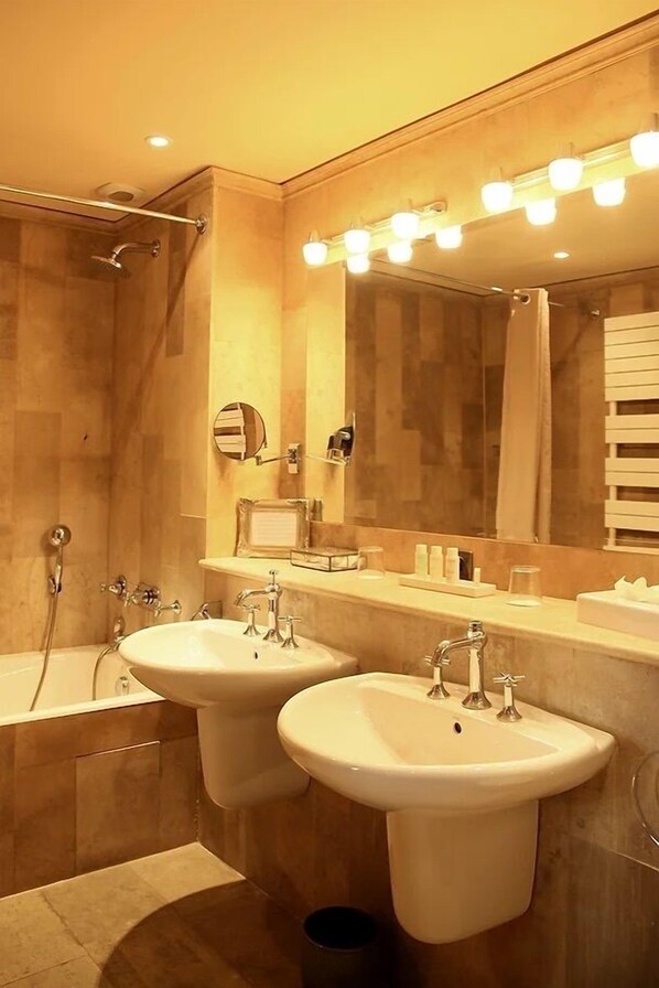 Une salle de bain avec deux lavabos, une baignoire et une douche.