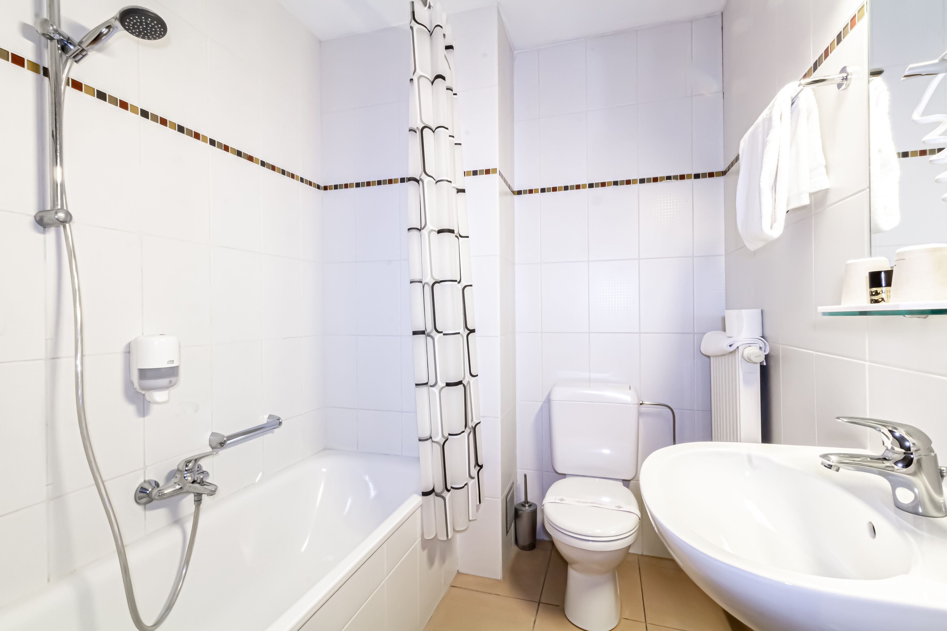 Un baño con bañera, ducha, inodoro y lavamanos.