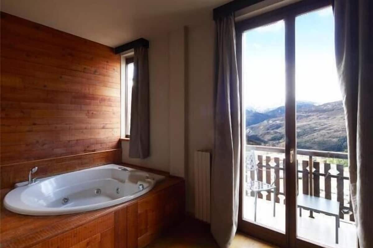 Quarto casal luxo, banheira de imersão, vista para a montanha | Edredons de pluma, frigobar, cofres nos quartos, escrivaninha
