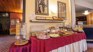 Una mesa de buffet con diversas opciones de comida y una estación de café.