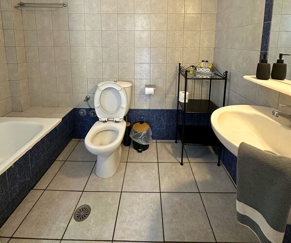 A bathroom with a toilet, sink, and bathtub.
