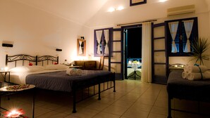 Un dormitori ben il·luminat amb un llit, taules de nit i vista cap a l'exterior.