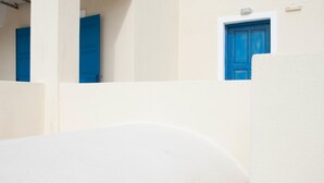 Un edifici blanc amb una porta blava i una finestra petita.