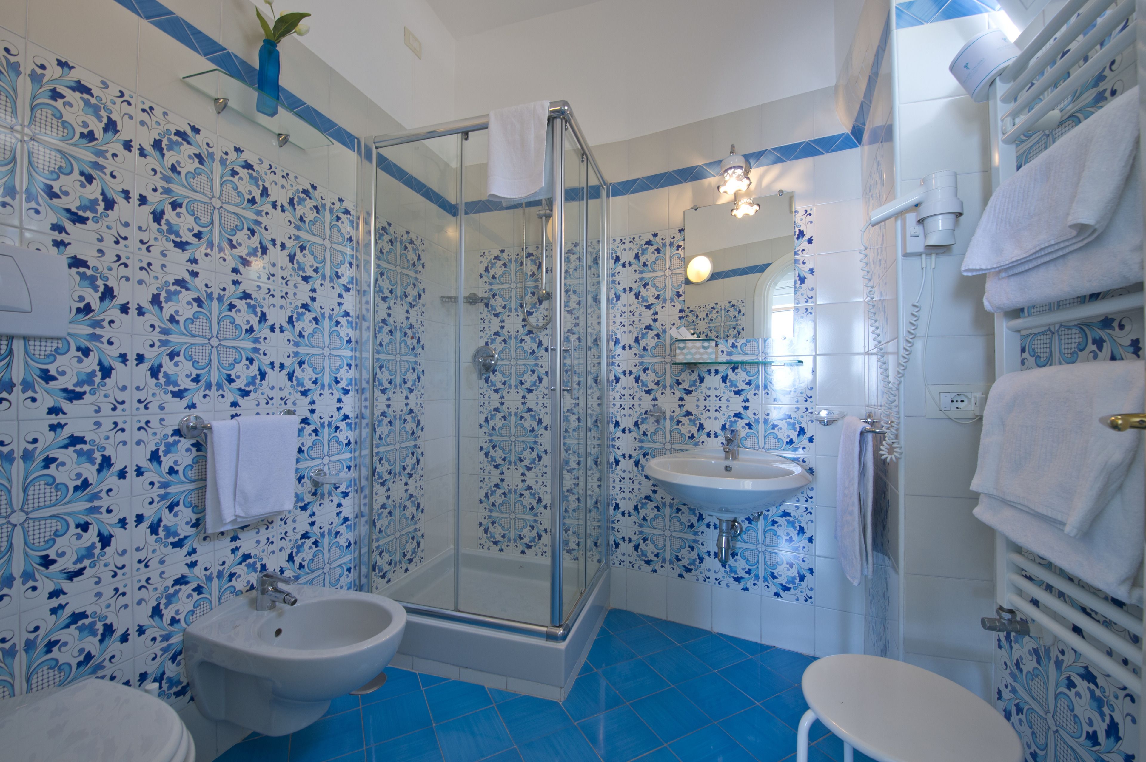Un baño con ducha acristalada, lavamanos y bidé.