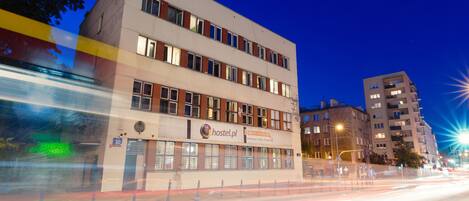 Une auberge de jeunesse avec une enseigne indiquant « hostel.pl » et le numéro « 30 » sur le bâtiment.