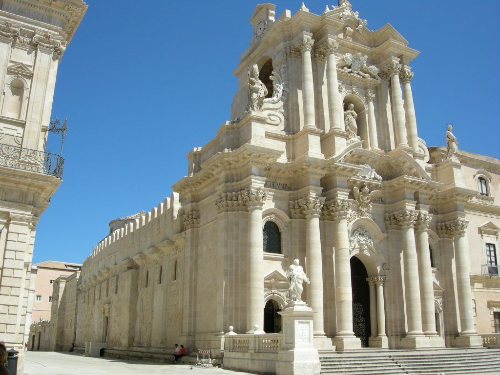 A grand historical building with classical architecture, featuring columns, statues, and intricate carvings.