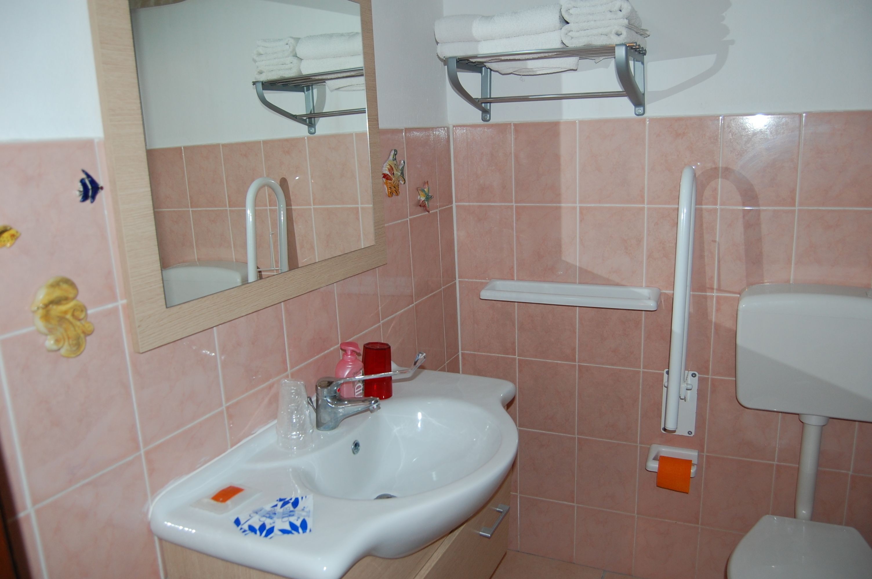 A bathroom with a sink, mirror, and toilet.