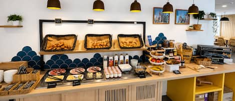 A buffet counter with various food items, a coffee machine, and a coffee station.