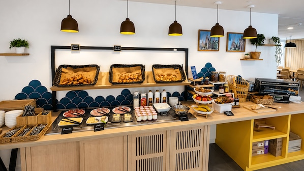 A buffet counter with various food items, a coffee machine, and a coffee station.