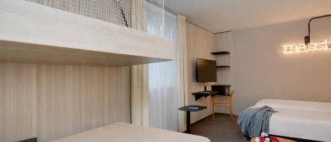 Una habitación de hotel con dos camas, un escritorio, una silla, un televisor y un letrero de neón.