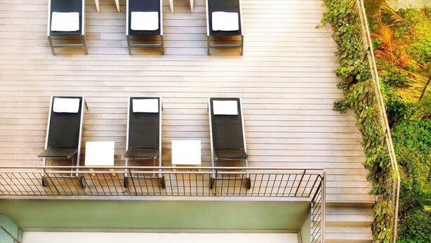 A rooftop pool with a view of the sky and a garden area with plants. - Aramunt Apartments (Barcelona)