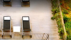A rooftop terrace with four sun loungers and a railing. - Aramunt Apartments (Barcelona)