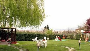A garden with a gazebo, a small table, and chairs. - Il Colombaino (Scandicci)