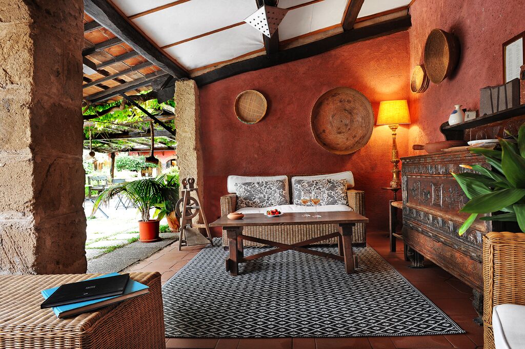 A cozy room with a wooden sofa, a patterned rug, and a rustic wooden cabinet.
