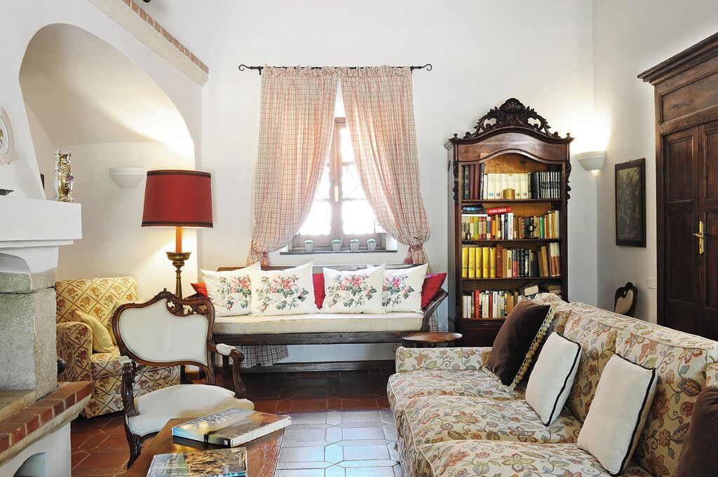 A cozy living room with a sofa, armchair, and a bookshelf.