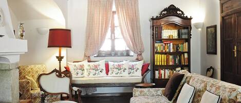 A cozy living room with a sofa, armchair, and a bookshelf.