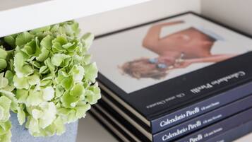 A bookshelf with a decorative metal sculpture, a potted plant, and a stack of books.