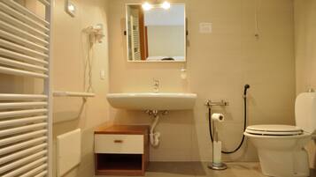 A bathroom with a sink, toilet, and a mirror above the sink.