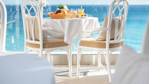 A dining table with chairs and a view of the ocean. - Le Roquebrune (Roquebrune-Cap-Martin)