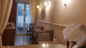 A dining area with a table, chairs, and a view of the outdoors. - La Dimora di Nettuno (Naples)