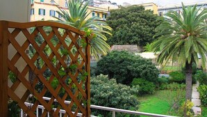A balcony with a wooden lattice, overlooking a garden with various plants and a view of surrounding buildings. - La Dimora di Nettuno (Naples)