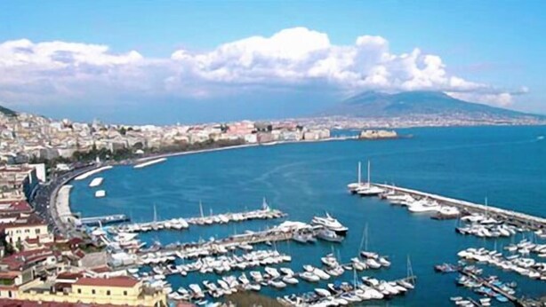 A marina with numerous boats docked, a coastal cityscape in the background, and a clear sky. - La Dimora di Nettuno (Naples)