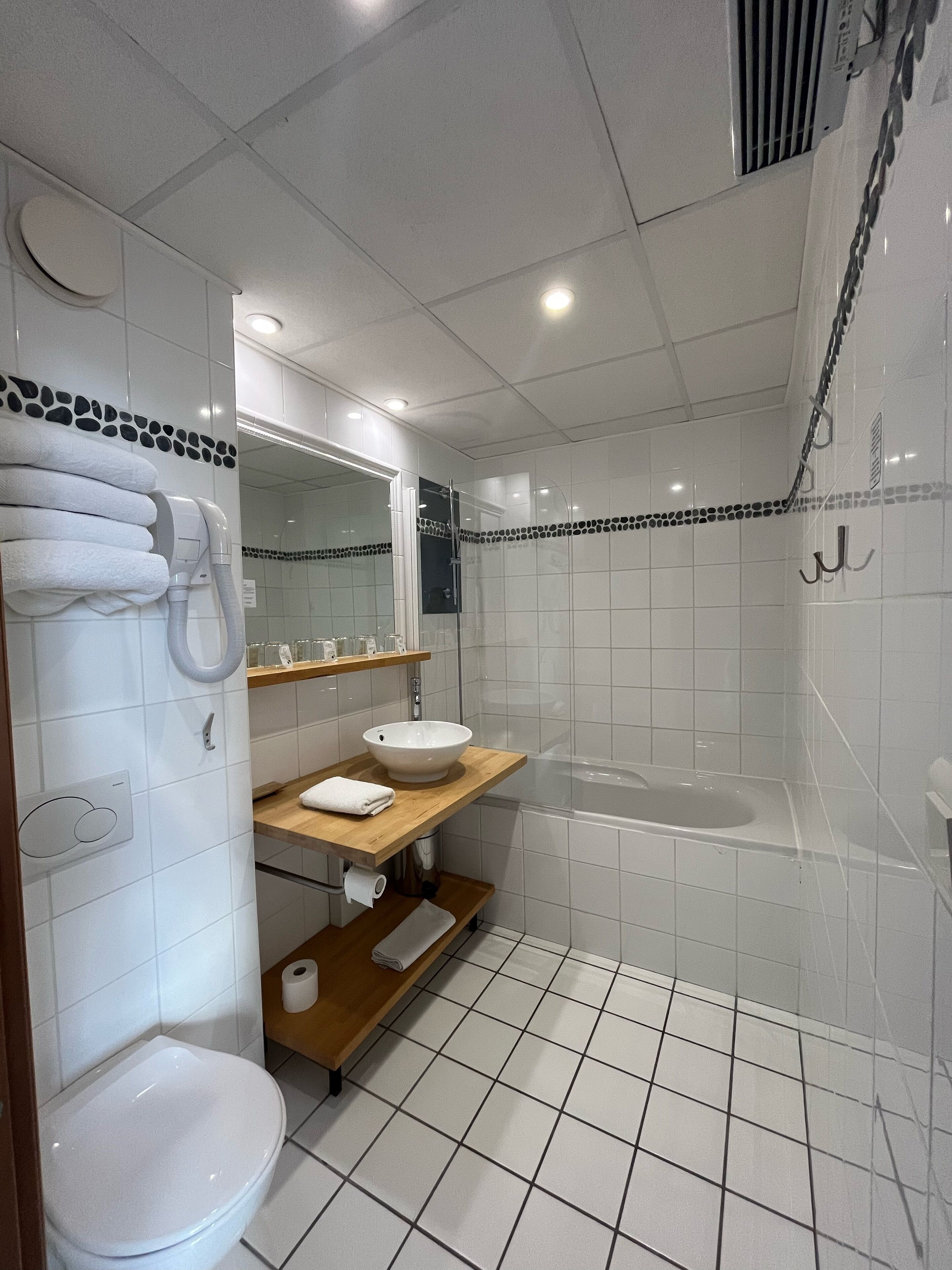 A modern bathroom with a toilet, sink, and shower.