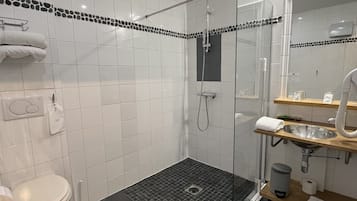 Ett modernt badrum med dusch, toalett och handfat.