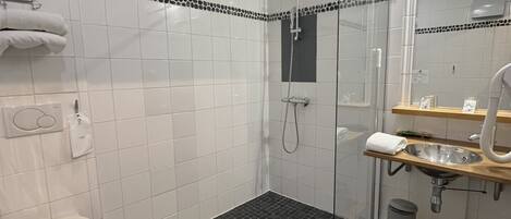 A modern bathroom with a shower, toilet, and sink.