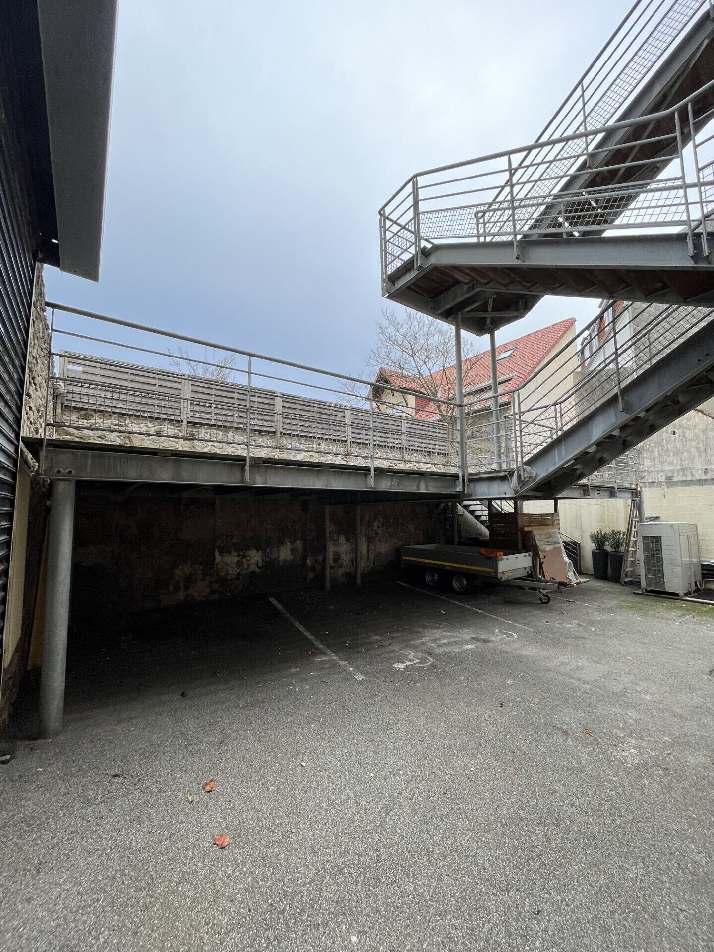 A parking area with a covered walkway and a truck loaded with boxes.