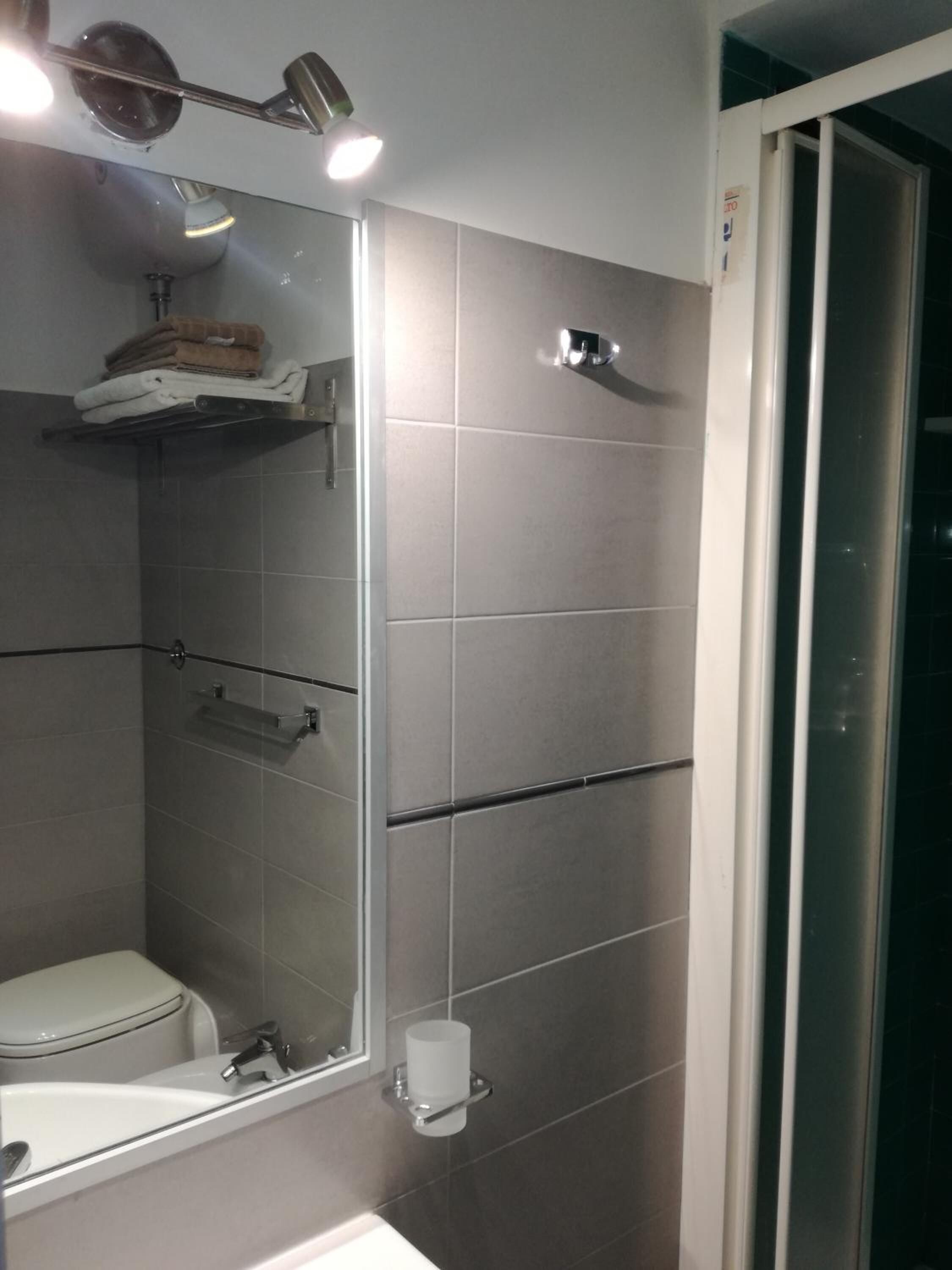 A modern bathroom with a toilet, sink, and shower area.