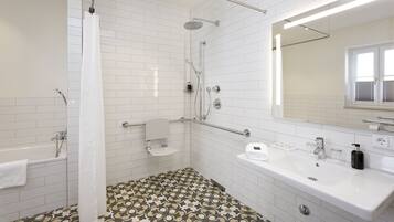 A modern bathroom with white tiles, a shower, a bathtub, a sink, and a mirror.
