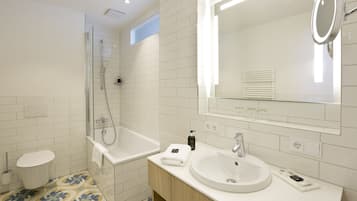 A modern bathroom with a glass shower enclosure, a white sink, and a large mirror.