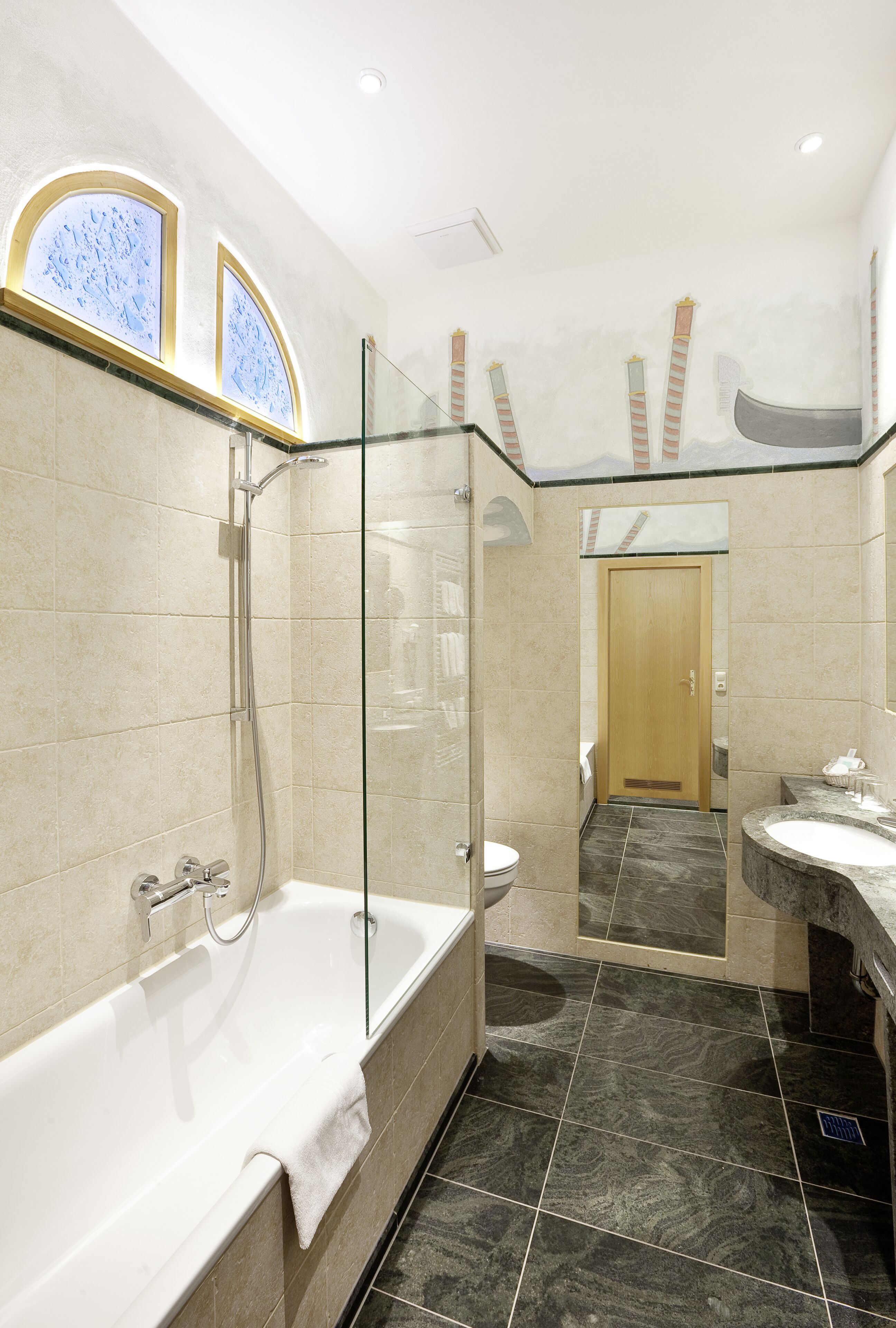 Un baño moderno con ducha de vidrio, una bañera independiente y un lavabo con tocador.