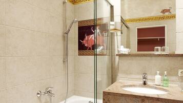 Een badkamer met een bad, douche en wastafel.