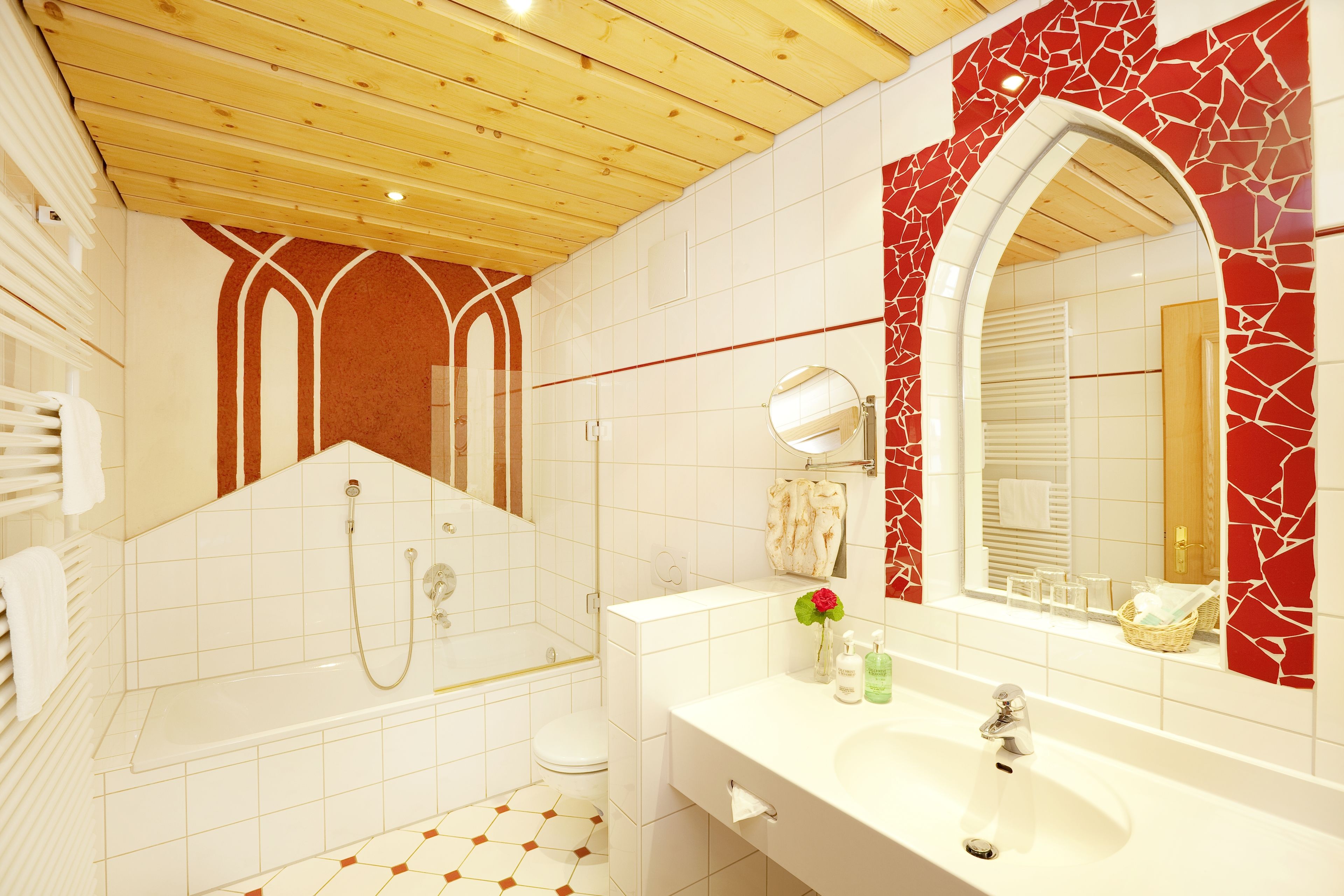 A bathroom with a bathtub, a toilet, a sink, and a mirror.