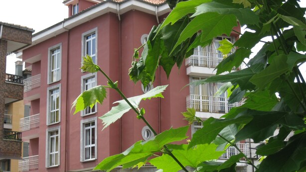 A multi-story building with balconies and a brick facade.