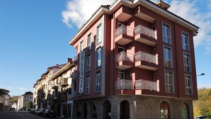 A multi-story hotel with balconies, arched windows, and a brick facade.