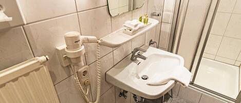 Un baño moderno con inodoro, lavamanos y ducha.