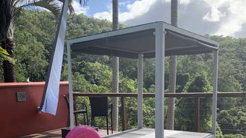 Relax on the deck, surrounded by lush greenery and a serene pool.