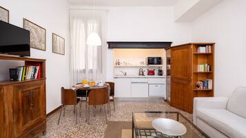 A compact living space with a dining area, kitchenette, and seating area.