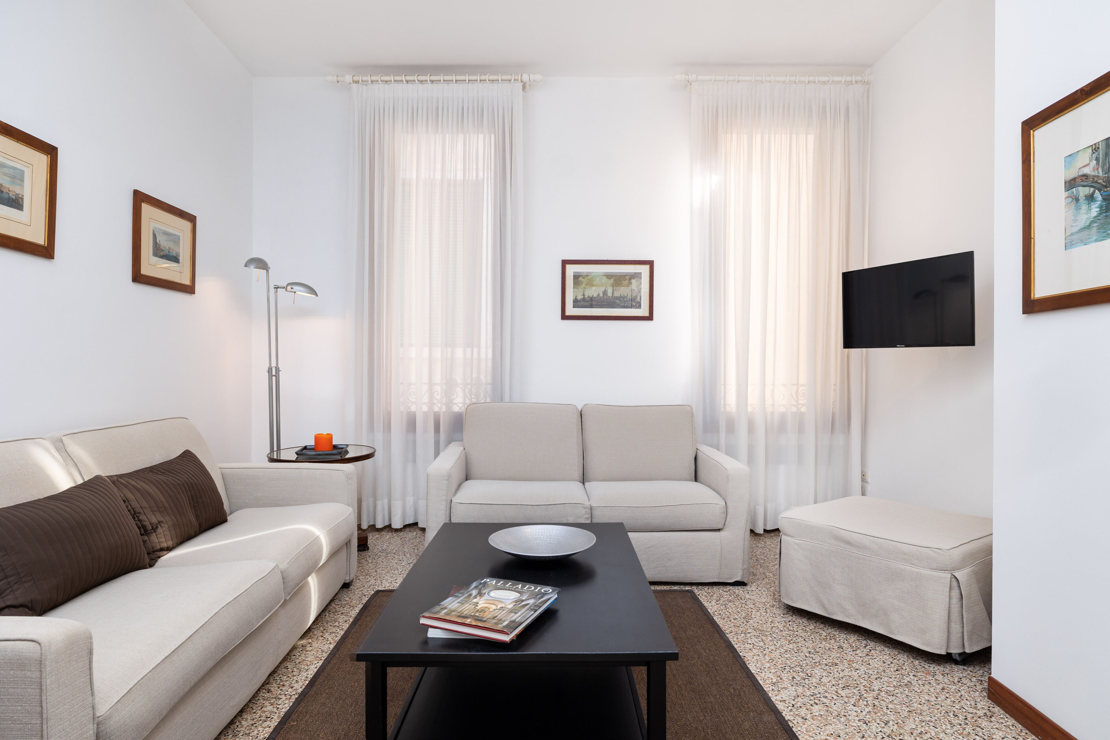Ein modernes Wohnzimmer mit einer Couch, einem Couchtisch und einem Fernseher.
