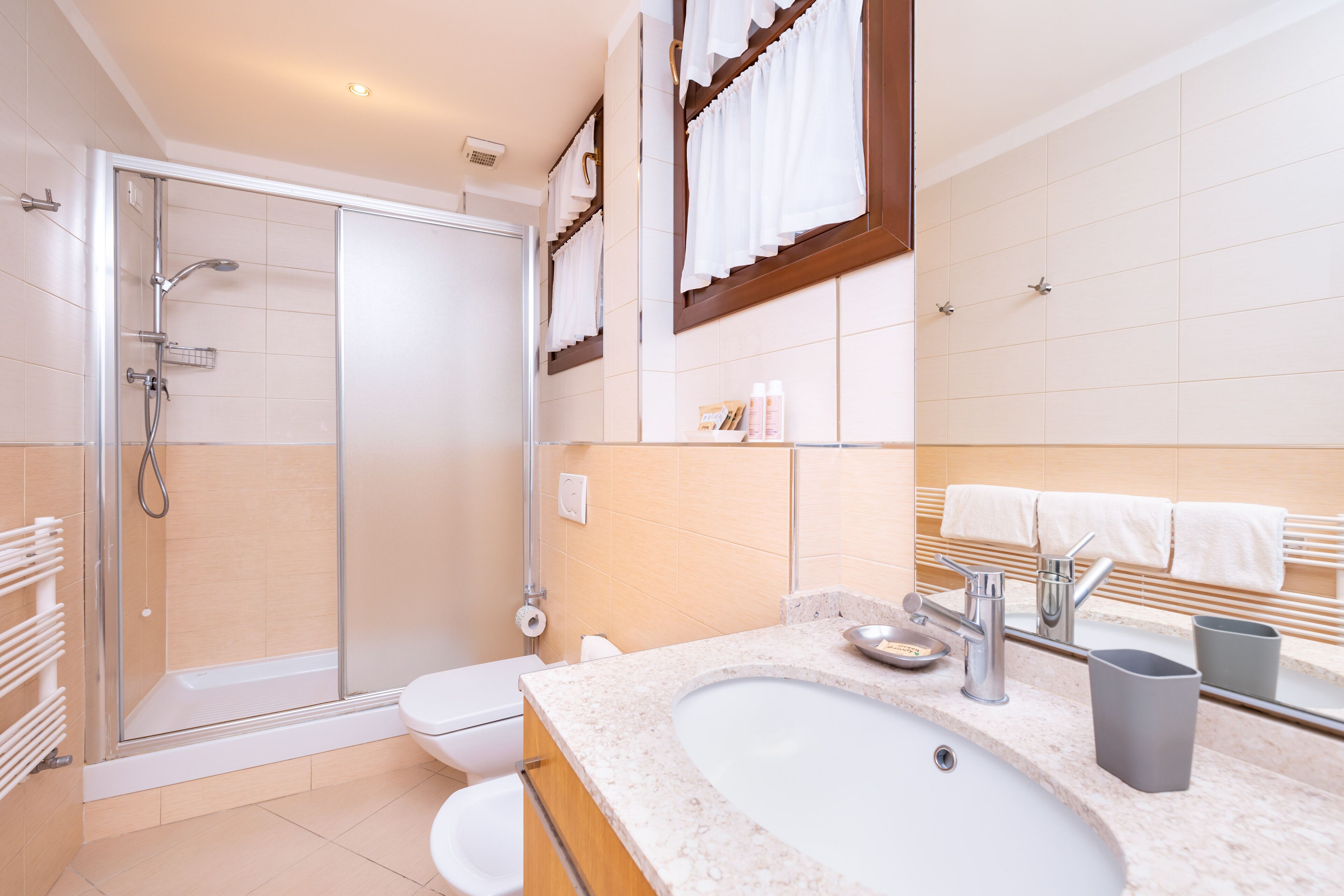 Une salle de bain moderne avec une douche à parois de verre, un lavabo blanc et un meuble-lavabo avec un miroir.