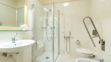 A modern bathroom with a glass-enclosed shower, a sink, and a toilet.