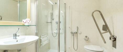 A modern bathroom with a glass-enclosed shower, a sink, and a toilet.